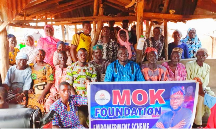 MOK Foundation representative distributing cash to underprivileged individuals in Shangbe, Ifelodun LG.